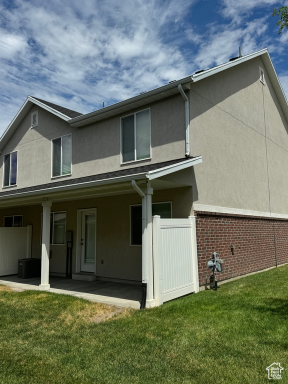 Back of property with a yard and a patio area