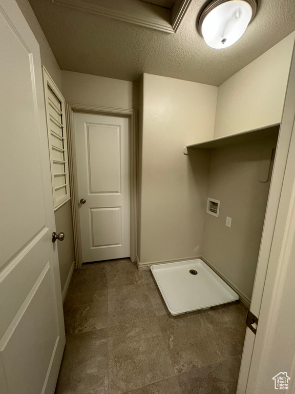 Clothes washing area featuring washer hookup and a textured ceiling