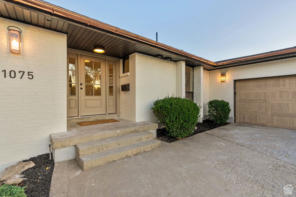 Exterior entry at dusk featuring a garage