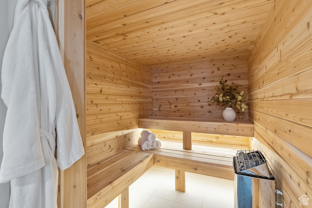 View of sauna / steam room featuring tile patterned floors, wood walls, and wooden ceiling