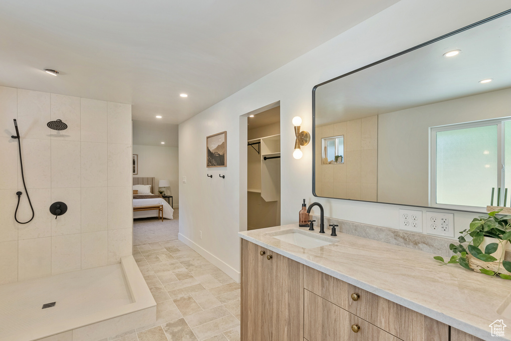 Bathroom featuring a tile shower and vanity