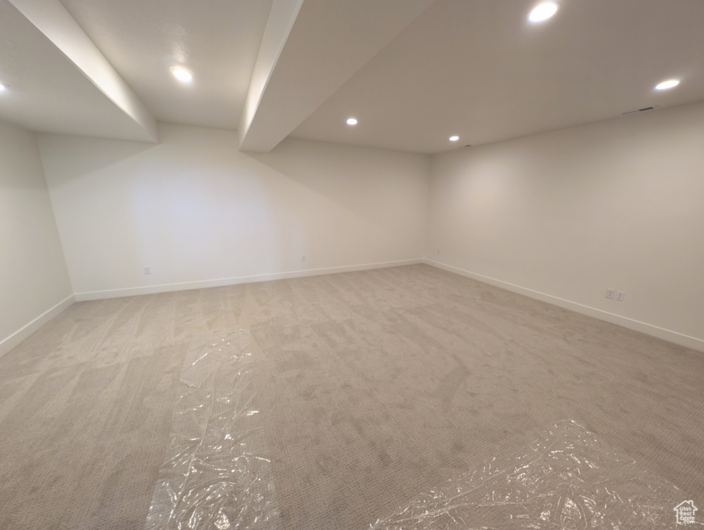 Basement featuring light colored carpet