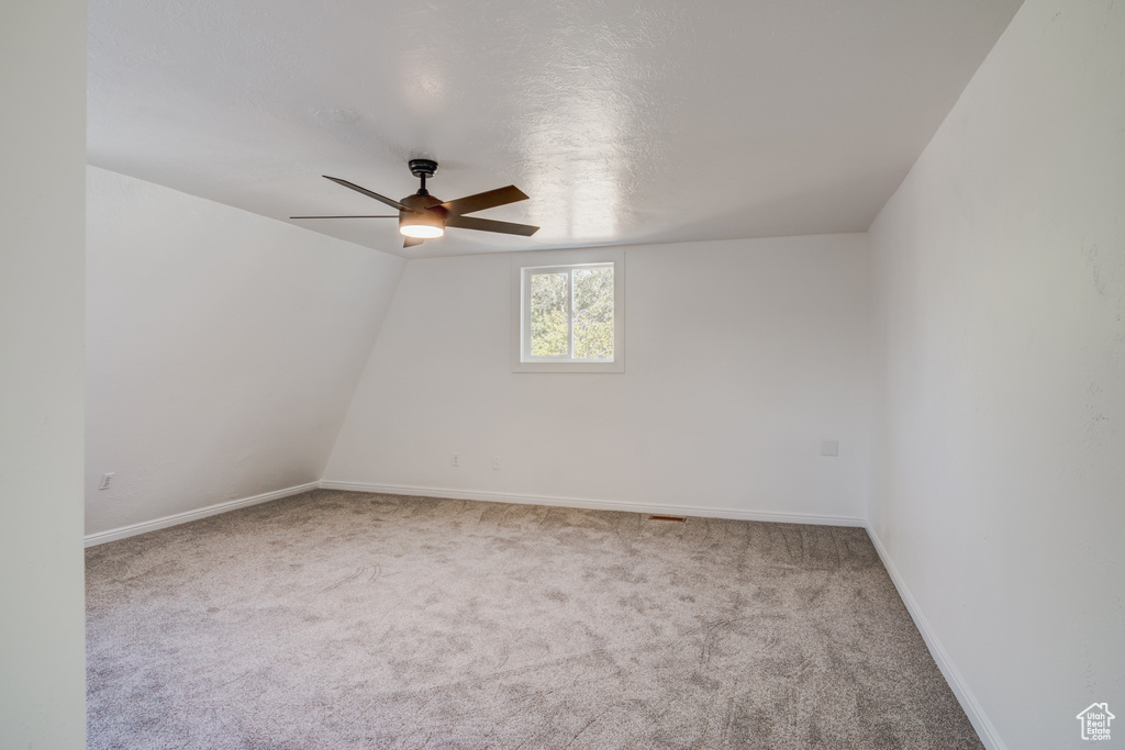 Carpeted empty room featuring a textured ceiling and ceiling fan