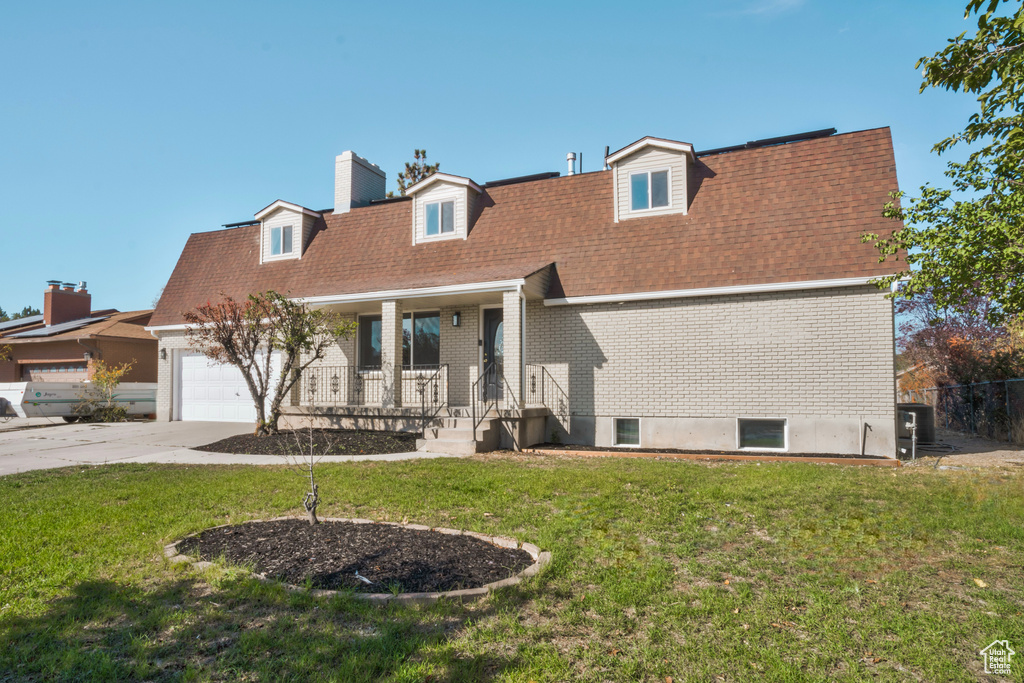 Rear view of property featuring a porch and a lawn