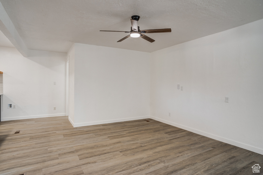 Unfurnished room with light hardwood / wood-style flooring, ceiling fan, and a textured ceiling