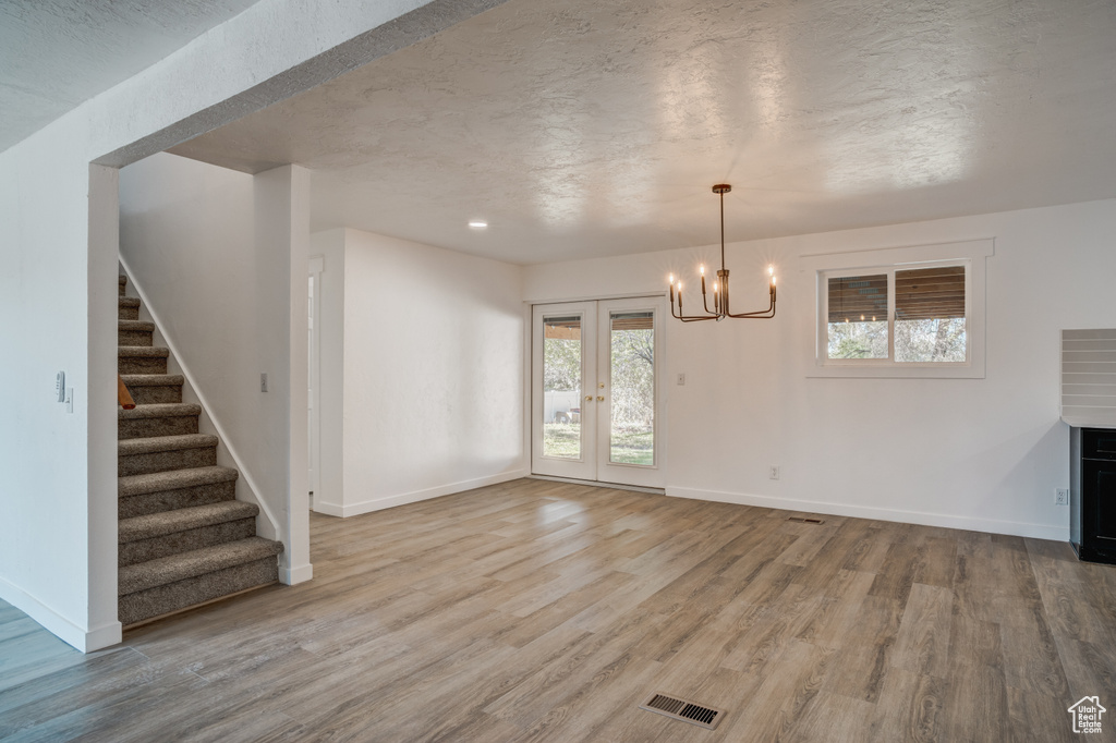 Interior space featuring hardwood / wood-style flooring, a chandelier, french doors, and a wealth of natural light