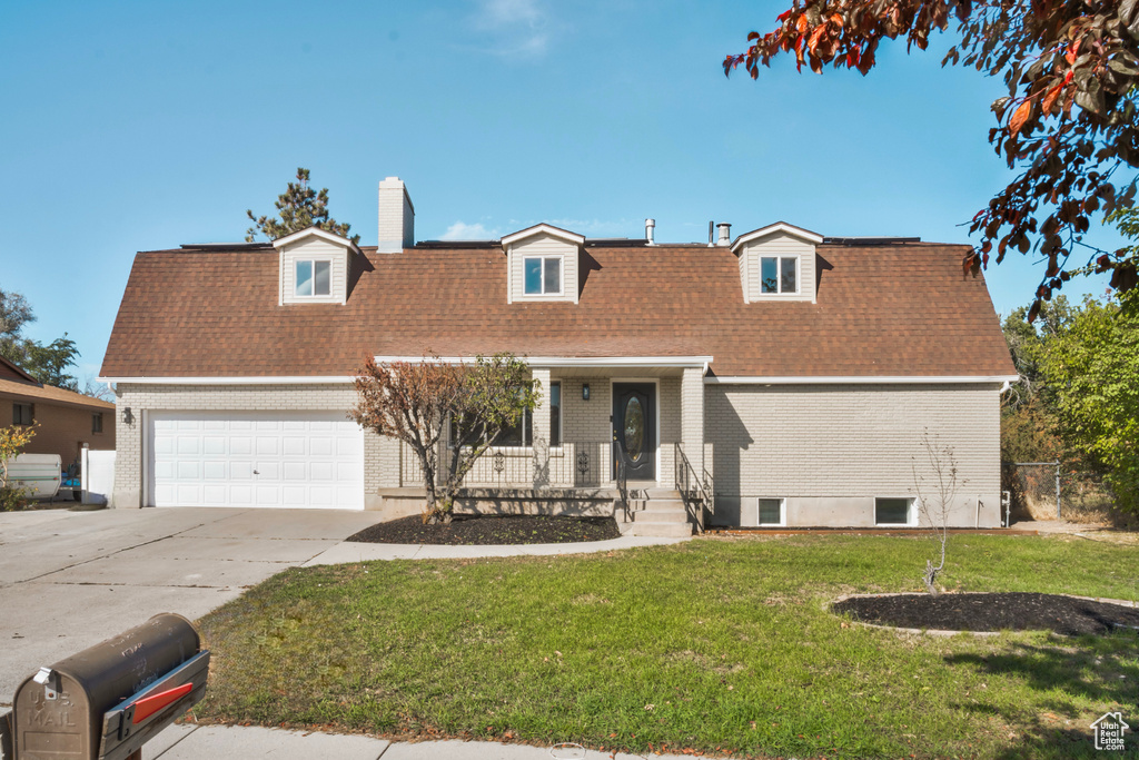 Cape cod-style house featuring a garage, a front yard, and covered porch