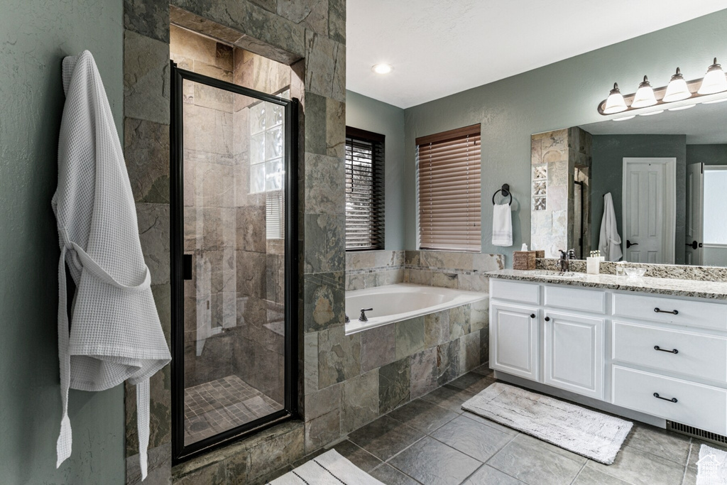 Bathroom featuring separate shower and tub and vanity