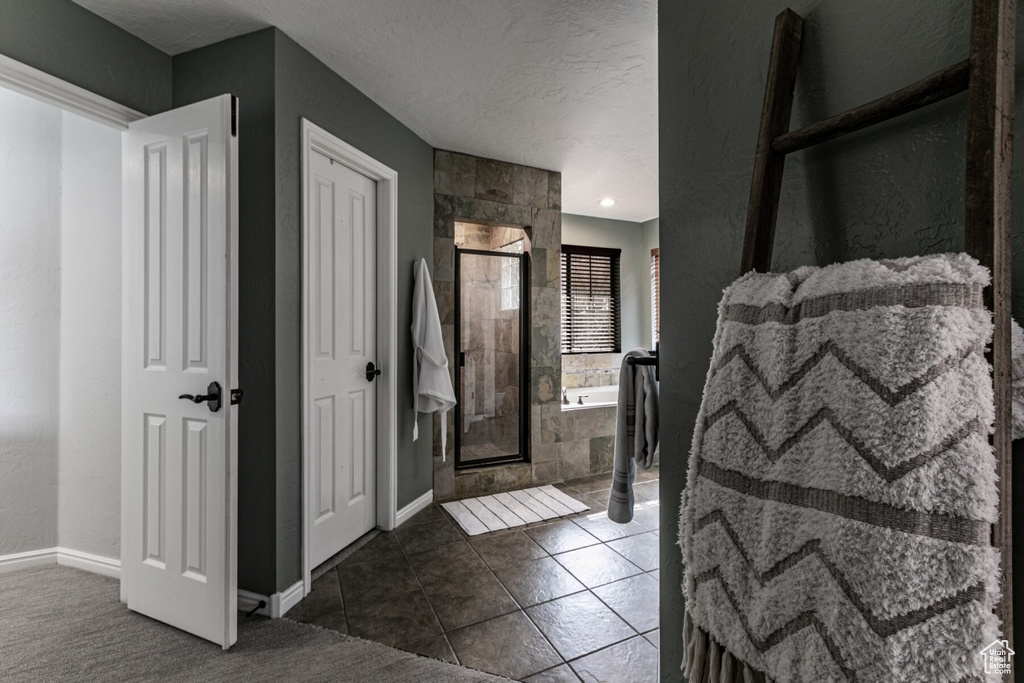 Entrance foyer featuring dark tile patterned flooring and a textured ceiling