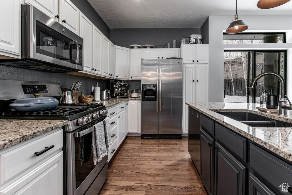 Kitchen with stainless steel appliances, white cabinets, and sink