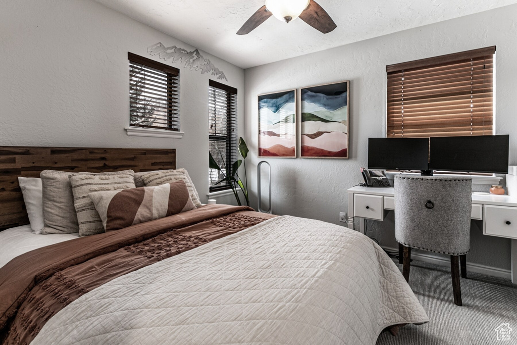 Carpeted bedroom featuring ceiling fan