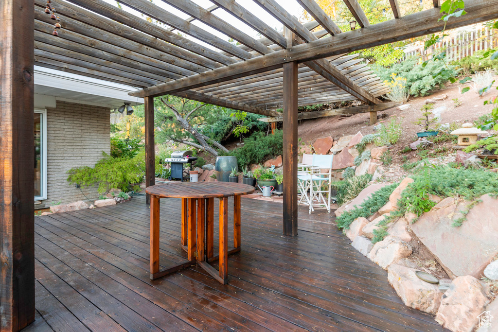 Wooden terrace with a pergola and area for grilling