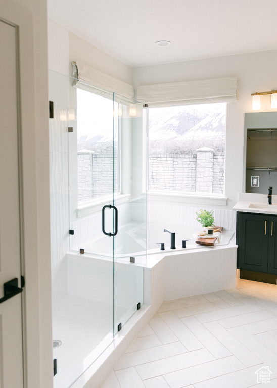 Bathroom with separate shower and tub, tile patterned floors, and vanity