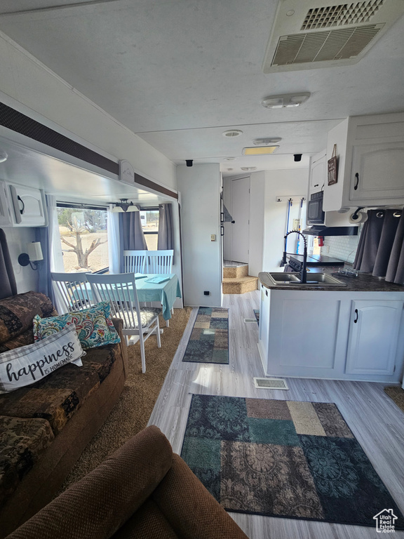 Living room with sink and light hardwood / wood-style floors