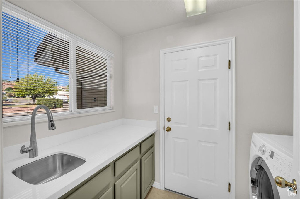 Clothes washing area with washer / clothes dryer, cabinets, and sink