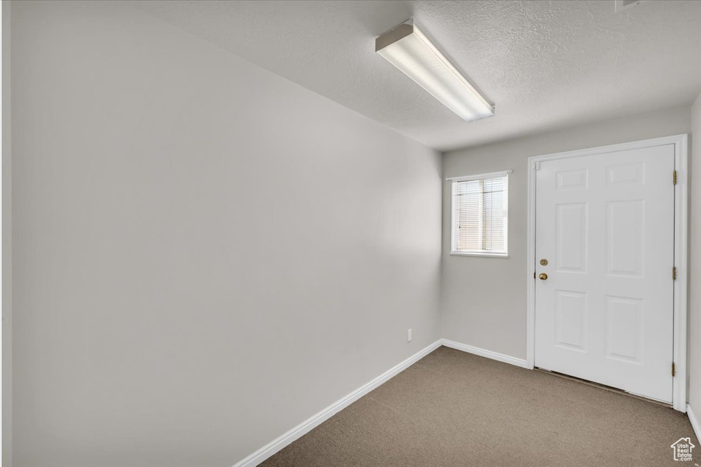 Carpeted empty room featuring a textured ceiling