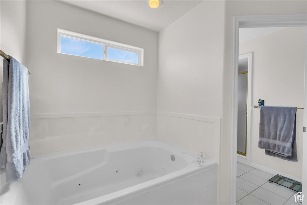 Bathroom with a bathtub and tile patterned flooring