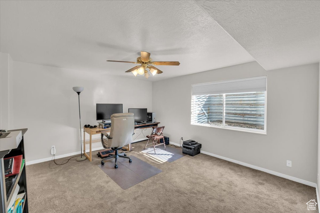 Home office with carpet floors, a textured ceiling, and ceiling fan