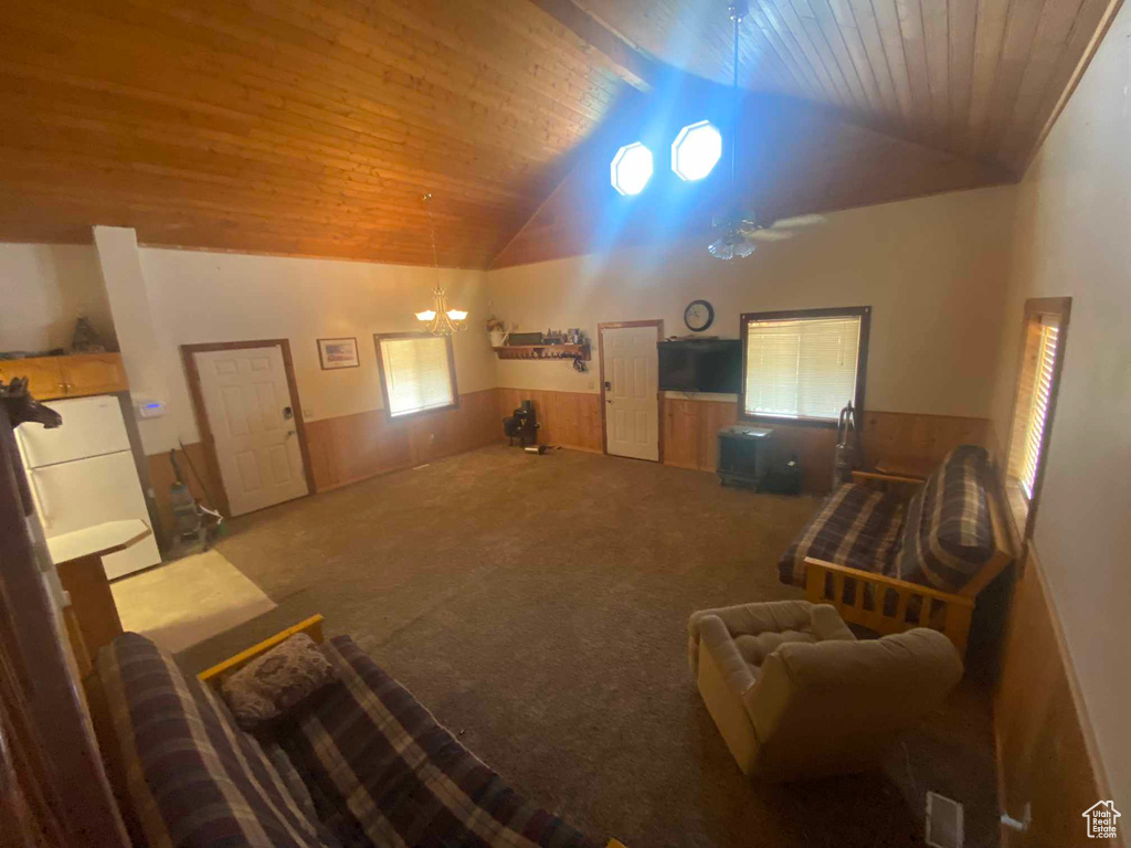 Living room featuring carpet floors, a notable chandelier, vaulted ceiling, and wooden ceiling