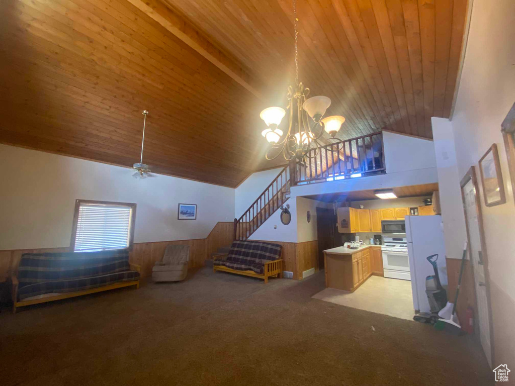 Carpeted living room featuring wooden ceiling, high vaulted ceiling, and wooden walls