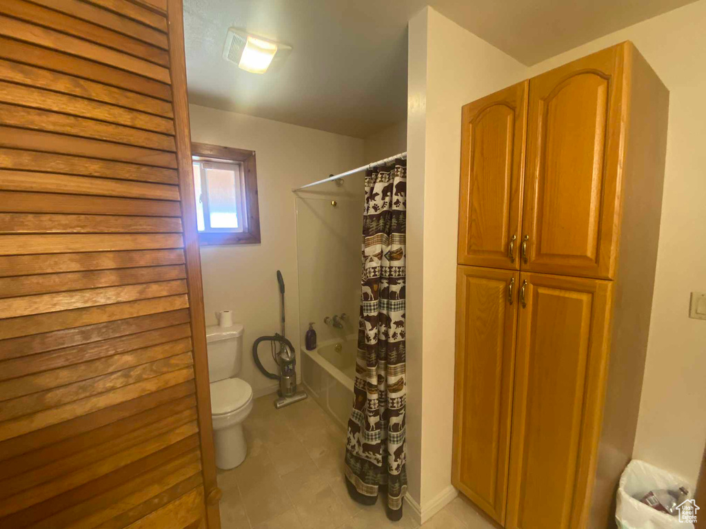 Bathroom with shower / tub combo and toilet