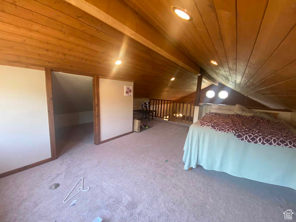 Unfurnished bedroom with carpet, wooden ceiling, and lofted ceiling with beams