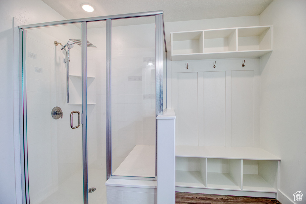 Bathroom featuring hardwood / wood-style flooring and a shower with shower door