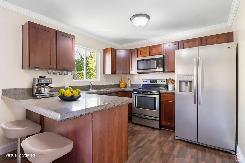 Kitchen with kitchen peninsula, dark hardwood / wood-style floors, crown molding, and stainless steel appliances