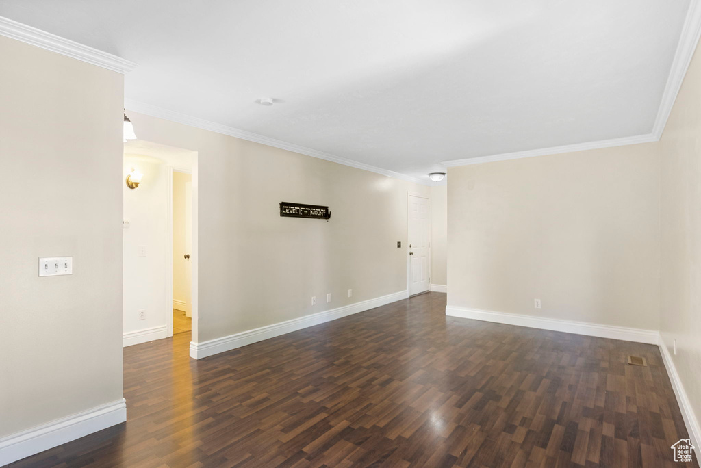 Unfurnished room featuring dark hardwood / wood-style floors and crown molding