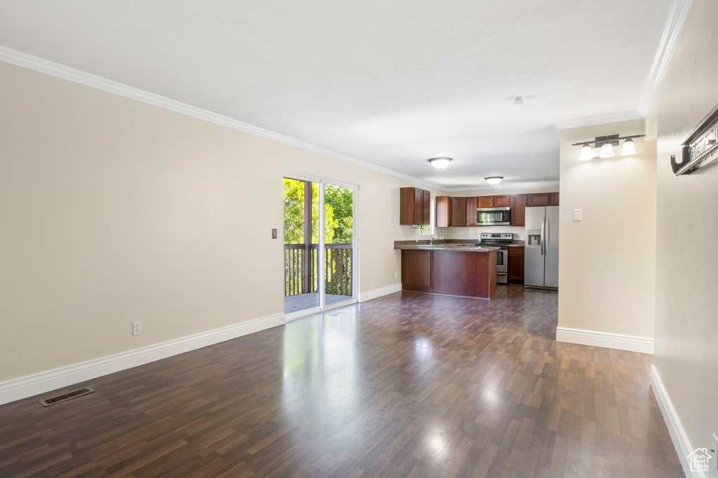 Unfurnished living room featuring crown molding and dark wood-type flooring