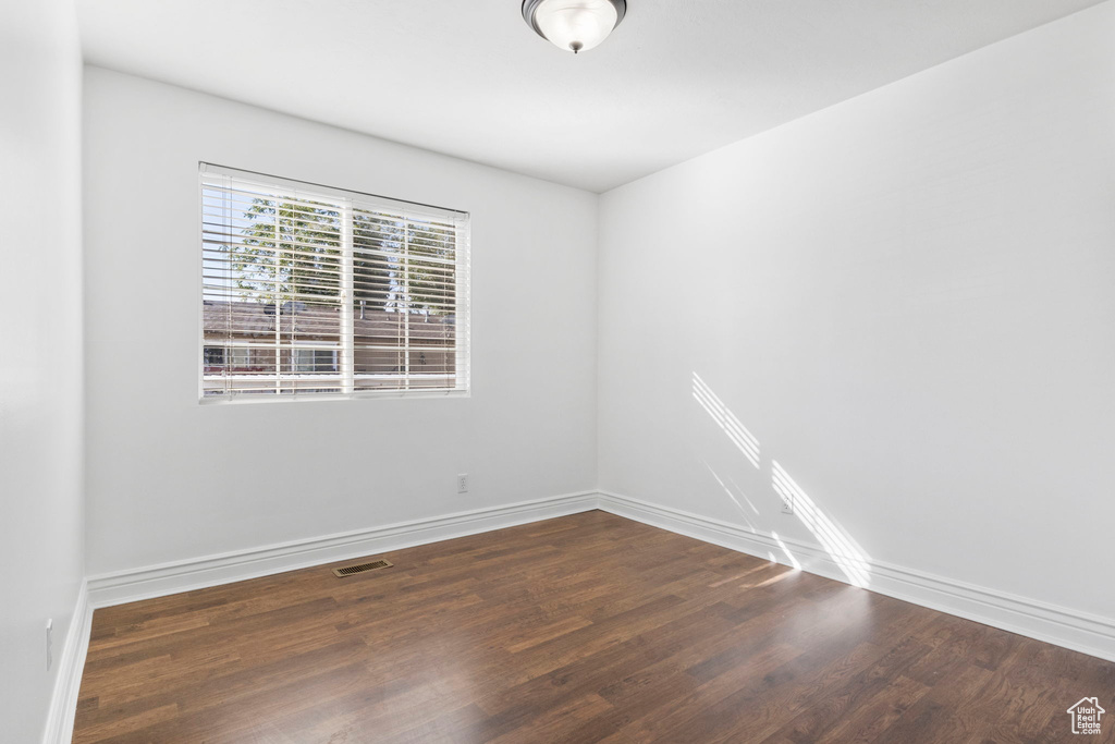 Spare room featuring dark wood-type flooring