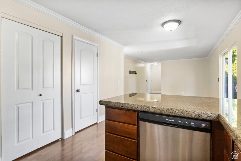 Kitchen featuring dishwasher, light stone countertops, crown molding, and dark wood-type flooring