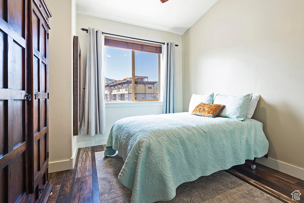 Bedroom featuring lofted ceiling and dark wood-type flooring