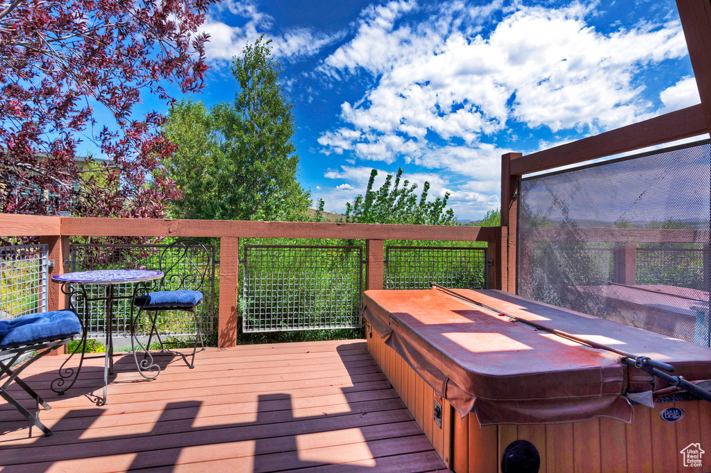 Wooden deck featuring a covered hot tub