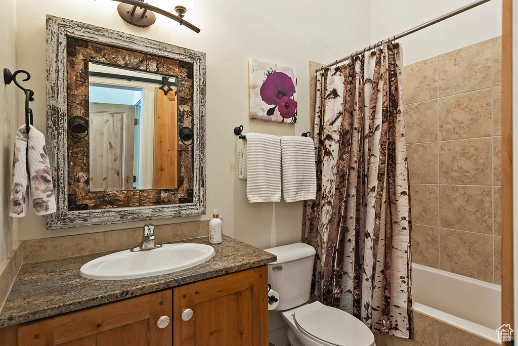 Full bathroom with vanity, toilet, and shower / bathtub combination with curtain