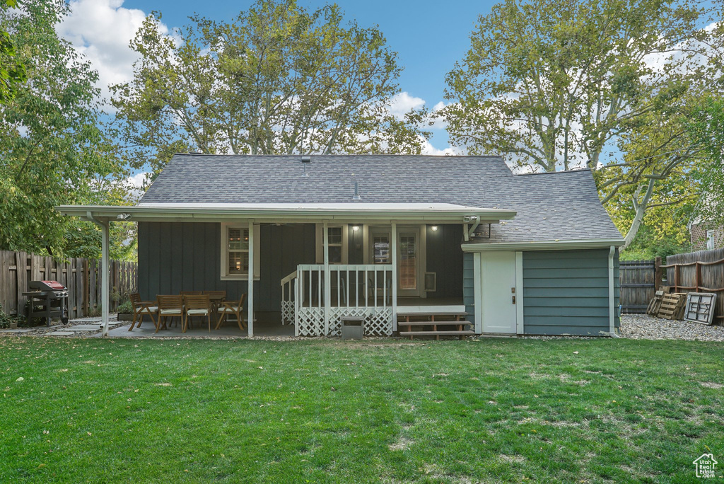 Back of house featuring a lawn and a patio area