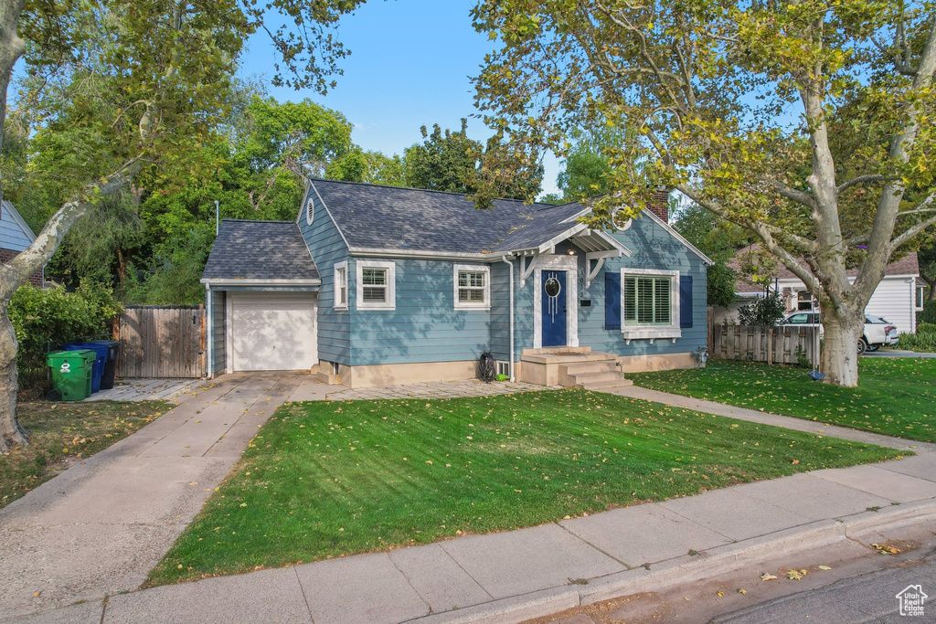 View of front of home with a front yard and a garage