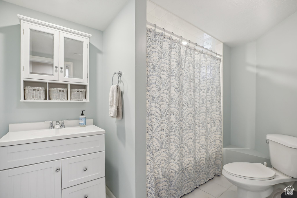 Full bathroom with vanity, toilet, shower / bathtub combination with curtain, and tile patterned floors