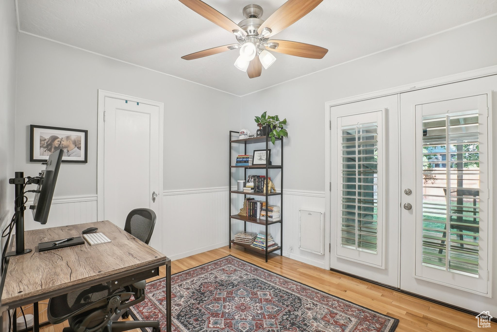 Office area with french doors, light hardwood / wood-style floors, and ceiling fan