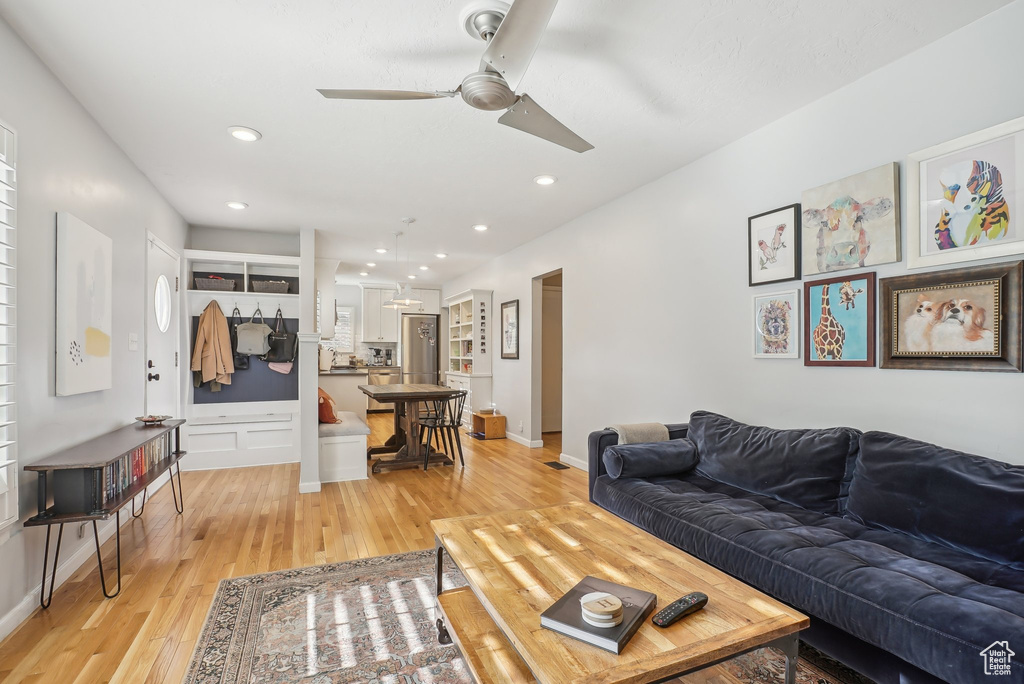 Living room featuring ceiling fan and light hardwood / wood-style flooring