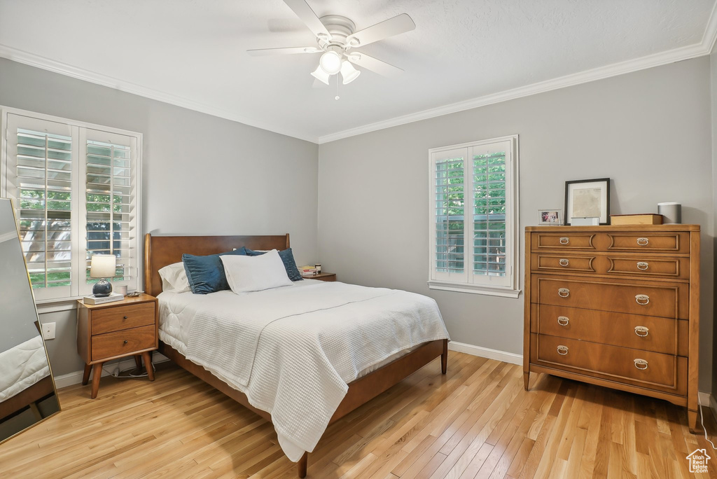 Bedroom featuring crown molding, light hardwood / wood-style flooring, and ceiling fan