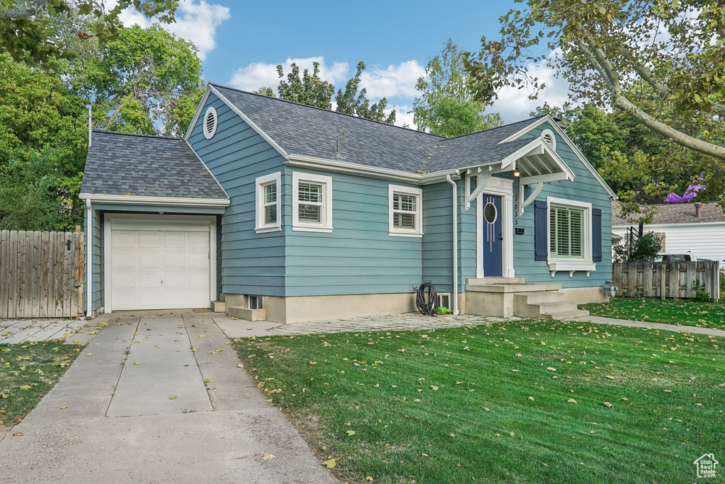 View of front facade with a garage and a front lawn