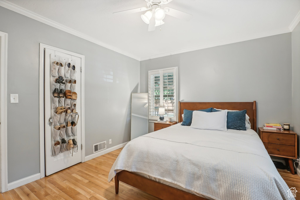 Bedroom featuring ceiling fan, light hardwood / wood-style flooring, and ornamental molding