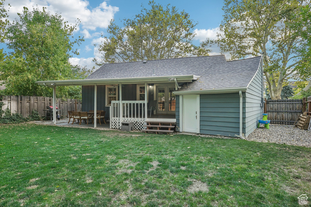 Back of property featuring a yard and a patio