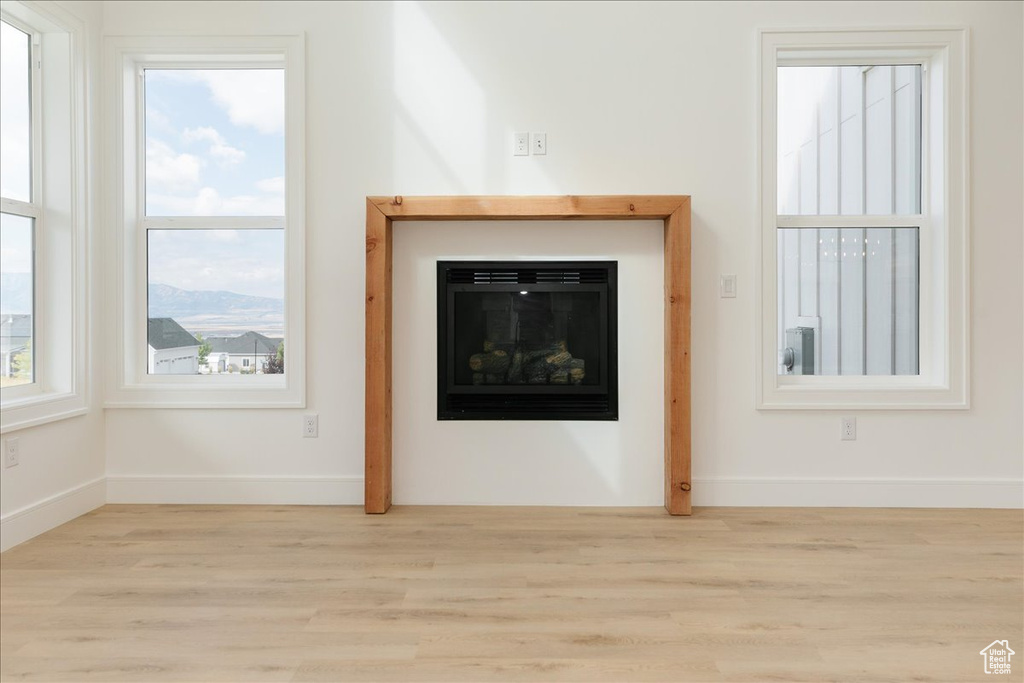 Unfurnished living room with a mountain view and light hardwood / wood-style floors