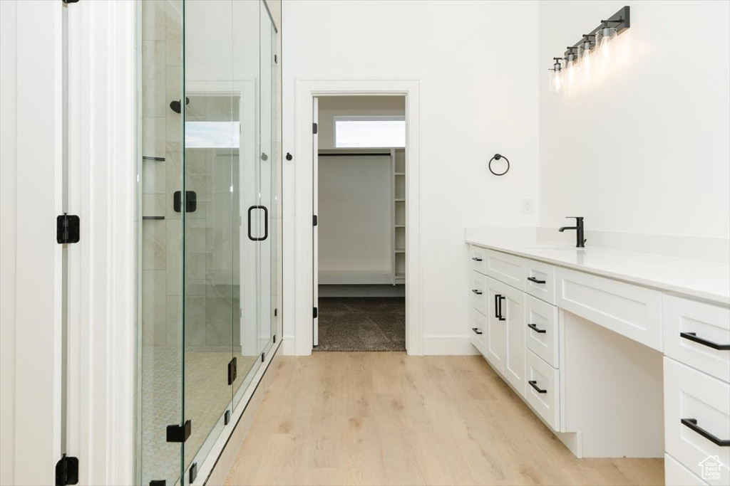 Bathroom featuring an enclosed shower, wood-type flooring, and vanity