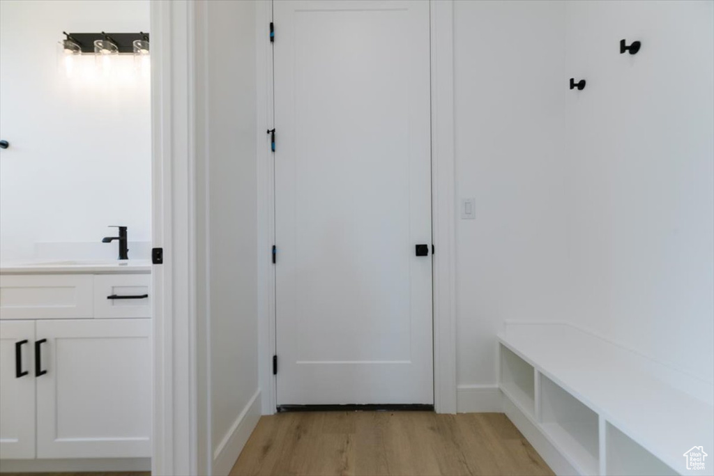 Mudroom with light hardwood / wood-style flooring and sink