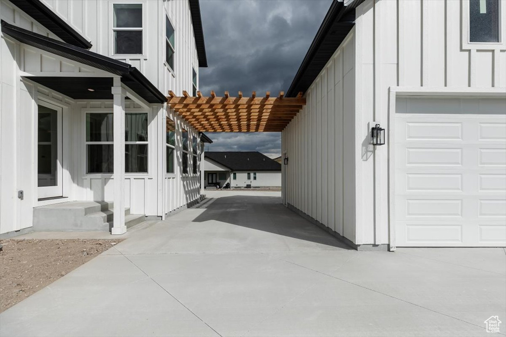 View of side of property with a pergola and a garage