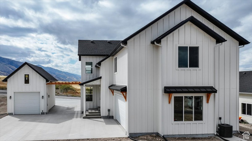 View of front of house featuring a mountain view, a garage, and an outbuilding