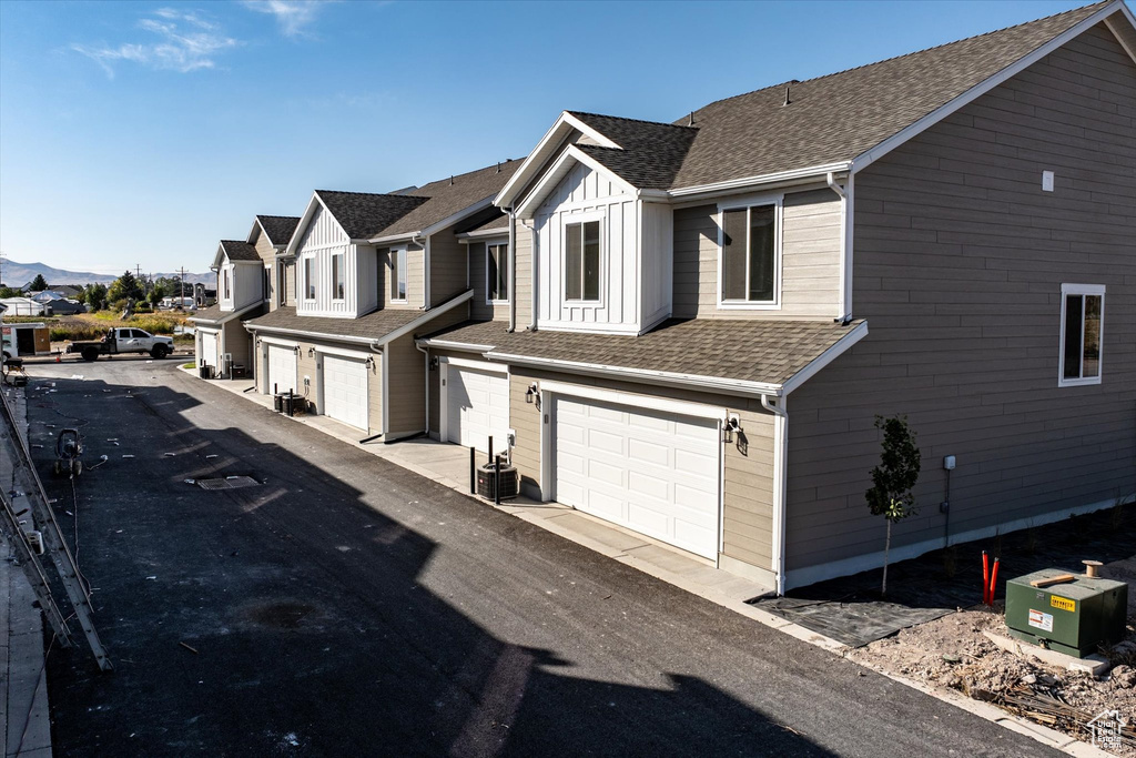 View of front of house with a mountain view, a garage, and central air condition unit